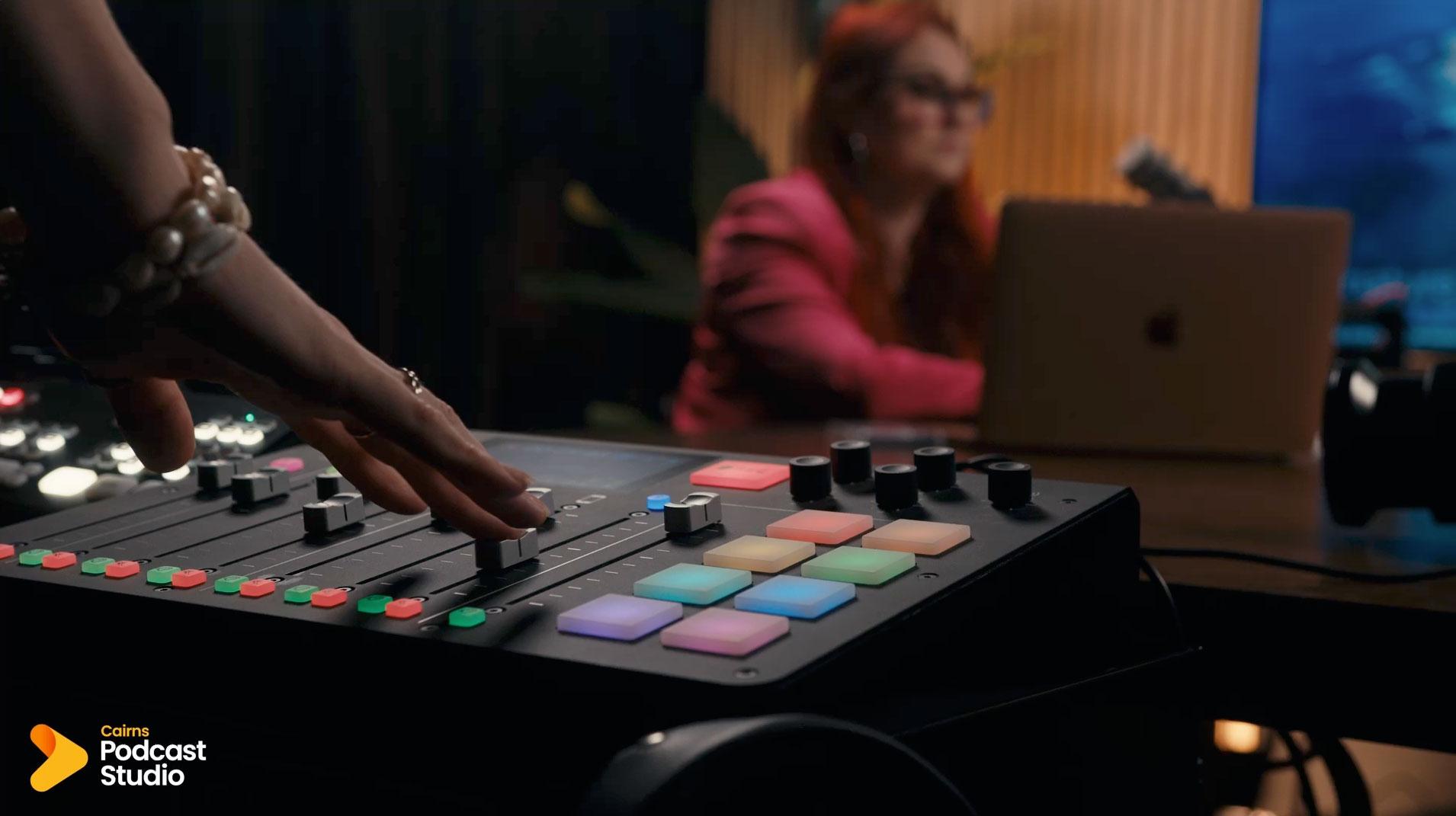 Hands on the podcast mixing desk during a recording at Cairns Podcast Studio